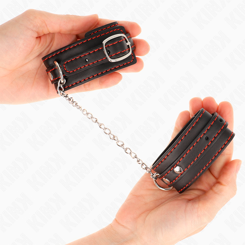 Punhos KINK pretos ajustáveis com forro vermelho para BDSM, exibindo o design e o material de alta qualidade.