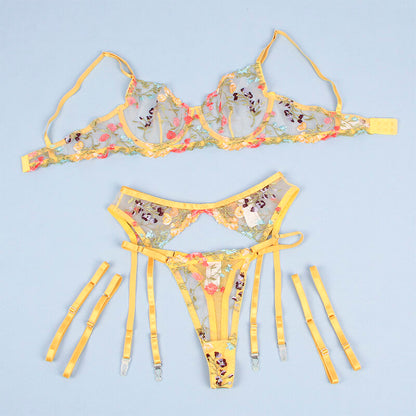 Close-up do Conjunto Lingerie SUBBLIME Floral Amarelo S/M, mostrando o sutiã, tanga e cinto-liga com detalhes florais.
