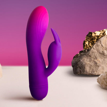 Close-up do Vibrador Rocks-Off Glo-Girl Rabbit, mostrando o design flexível e aveludado de silicone para dupla estimulação.