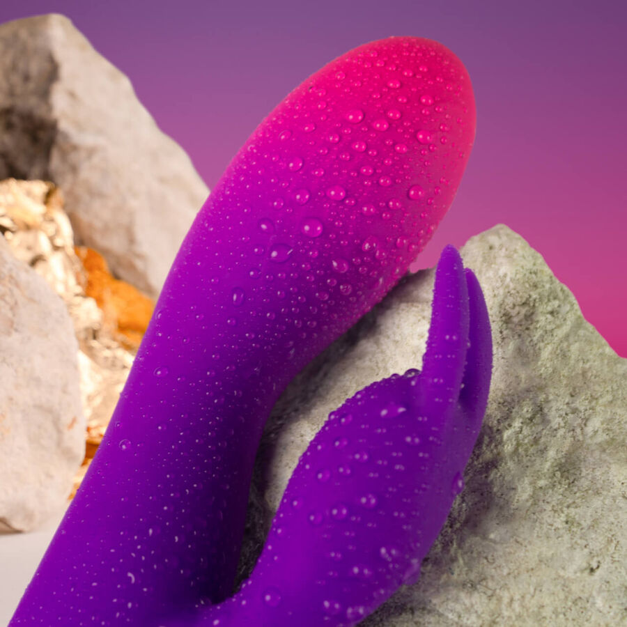 Close-up do Vibrador Rocks-Off Glo-Girl Rabbit, mostrando o design flexível e aveludado de silicone para dupla estimulação.